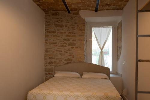 a bedroom with a bed and a brick wall at Rosmaris - Villa nel verde in Francavilla al Mare