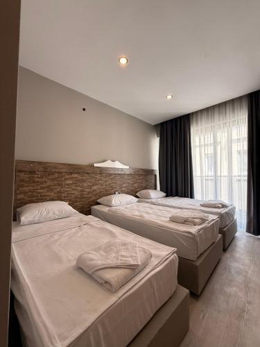 a bedroom with three beds and a brick wall at Livane Beach Hotel in Alanya