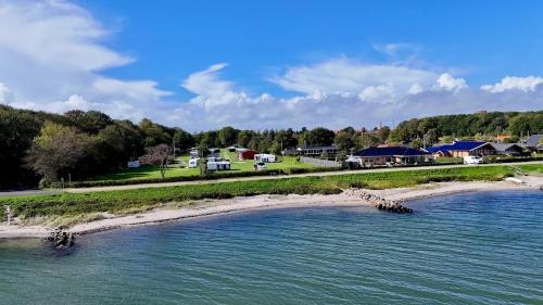 an island in the water with houses in the background at Morsø Camping in Nykøbing Mors