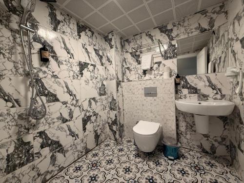 a bathroom with a toilet and a sink at Livane Beach Hotel in Alanya