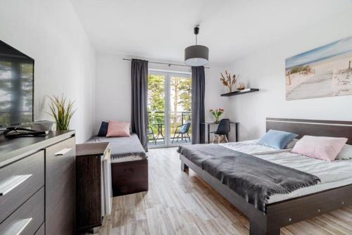 ein Schlafzimmer mit zwei Betten und eine Küche mit Fenster in der Unterkunft D.W Nawigator in Ostrowo