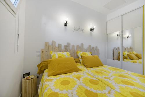 a bedroom with a bed with yellow pillows at Comme à la maison in Ducey