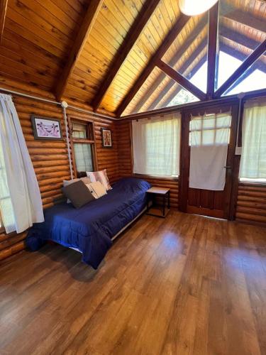 a bedroom with a bed in a room with wooden walls at La Posada del Hobbit in Villa Ventana