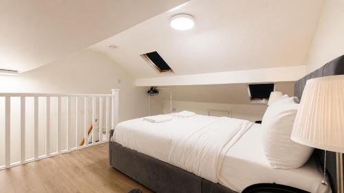 a bedroom with a large bed with white sheets at Cosy Flat on the Top Floor in Ramsbottom in Ramsbottom
