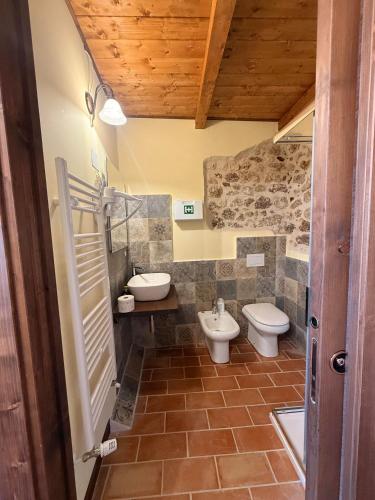 a bathroom with two toilets and a sink at Arcem in Calascio
