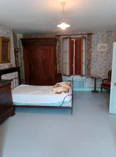 a bedroom with a bed with a dog laying on it at Maisonnette de village in Mosnes