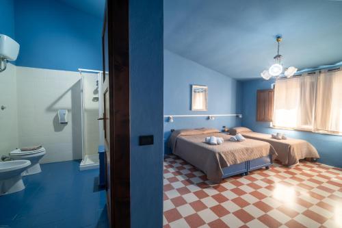 a blue room with two beds and a bathroom at Sa Mola in Bonarcado