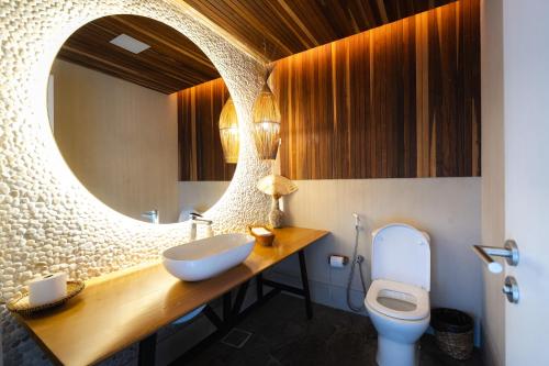 a bathroom with a sink and a toilet and a mirror at Tintto Hotel in Fortaleza