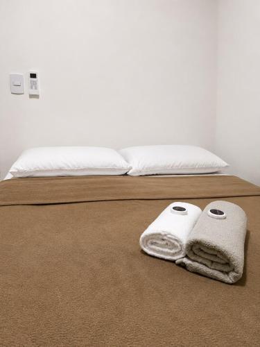 a bed with two towels on top of it at Manaira Suite 02 in João Pessoa