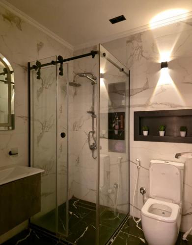 a bathroom with a glass shower and a toilet at كمبوند العالمية in Madinat Al Ashir min Ramadan