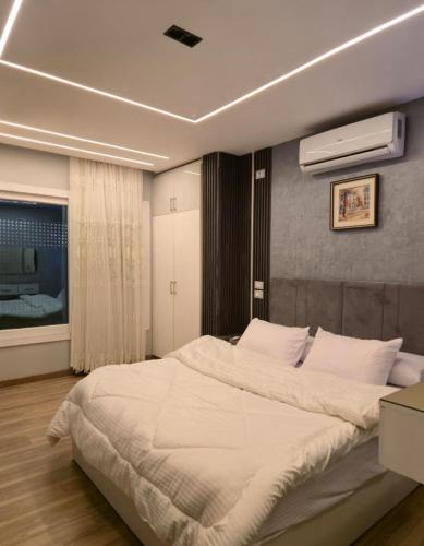 a bedroom with a large white bed in it at كمبوند العالمية in Madinat Al Ashir min Ramadan