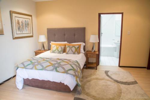 a bedroom with a large bed and a bathroom at Misty Blue Bed and Breakfast in Durban