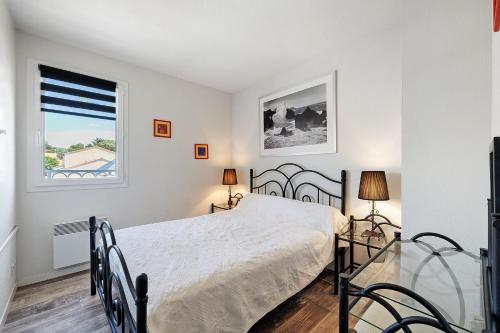 a bedroom with a bed and a window at Maison La Parée Plage in Bretignolles-sur-Mer