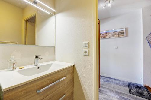 a bathroom with a sink and a mirror at Maison La Parée Plage in Bretignolles-sur-Mer