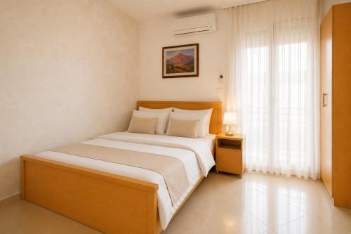a bedroom with a large bed and a window at Apartments Taida in Dobra Voda