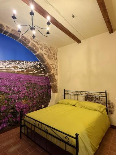 a bedroom with a bed with a painting of a field of flowers at Arcem in Calascio