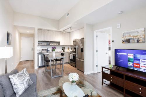 a living room with a couch and a table and a kitchen at Luxury Apartment In Harbor Point in Stamford