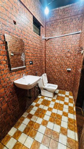 a brick bathroom with a sink and a toilet at guest house carolina in Colva