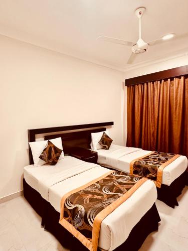 two beds in a hotel room with at Britstar Suites Salalah in Salalah