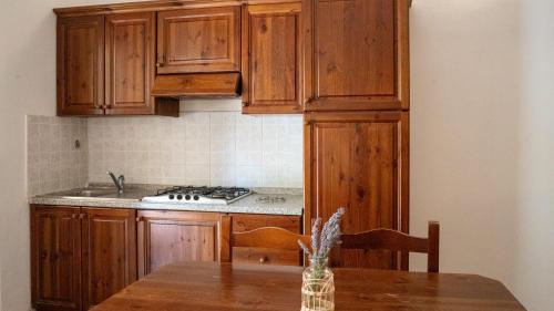 a kitchen with wooden cabinets and a wooden table at Agriturismo Fara del Falco in Vieste