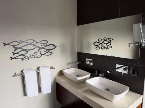 a bathroom with a white sink and a mirror at The Ocean View Guest House in Wilderness