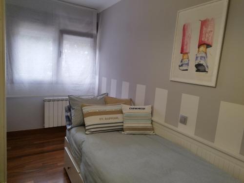 a bedroom with a bed with pillows on it at Apartamento El Ferial in Sarón