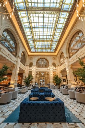 a large room with tables and chairs in a building at The Marmorosch Bucharest, Autograph Collection in Bucharest