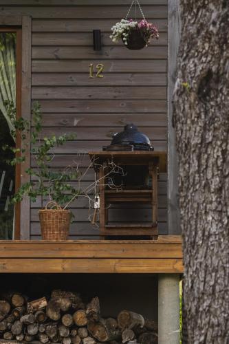 a wooden bench with a stove on it next to a tree at Obuoliu sala Moletu Vila in Gaylyunay
