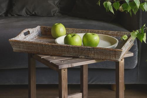 a wooden tray with a bowl of apples on a table at Obuoliu sala Moletu Vila in Gaylyunay