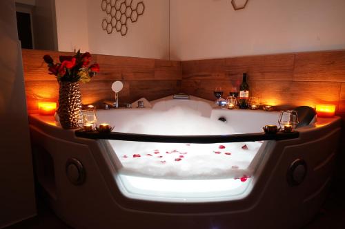a bath tub with flowers and candles in a room at Jacuzzi Przemyska in Krakow