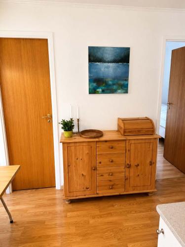 a room with a wooden cabinet with a painting on the wall at Saksun Mountain & Beach Cottage in Saksun