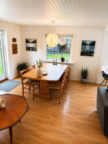 a living room with a wooden table and chairs at Saksun Mountain & Beach Cottage in Saksun