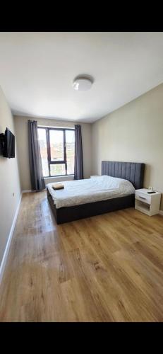 a bedroom with a bed and a large window at CIty view apartment in Gotse Delchev