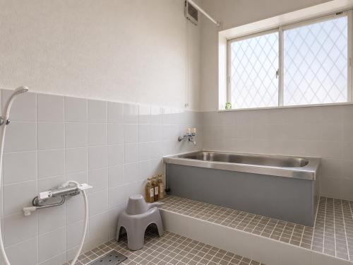 a bathroom with a bath tub and a sink at Daiwa House BBQ 琵琶湖徒步3分 無料駐車4台プロジェクター in Takashima