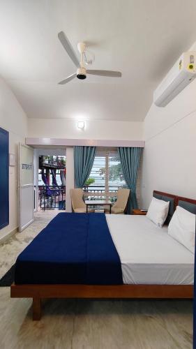 a bedroom with a large bed with a ceiling fan at Avanthi Homestay in Varkala