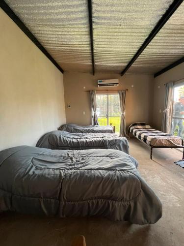 a room with four beds in it with a ceiling at Las catalinas in General Rodríguez