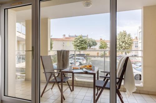 a balcony with a table and chairs and a window at Résidence Pierre & Vacances La Baie des Sables in Les Sables-d'Olonne