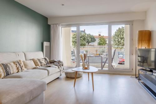 a living room with a couch and a tv at Résidence Pierre & Vacances La Baie des Sables in Les Sables-d'Olonne