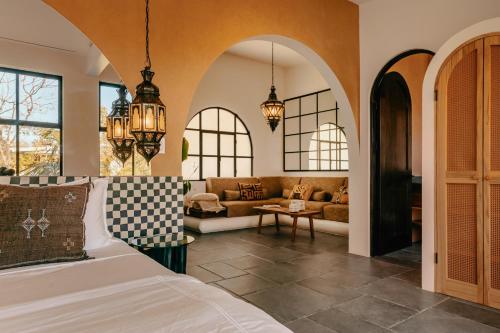 a bedroom with a bed and a living room at Domo Nosara Boutique Hotel in Nosara