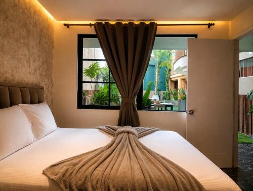 a bedroom with a bed with a window at DUO BOUTIQUE HOTEL in Medellín