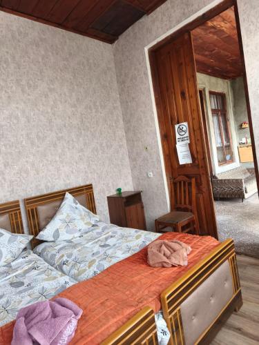 a bedroom with a bed with an orange comforter at Cozy home in Zugdidi
