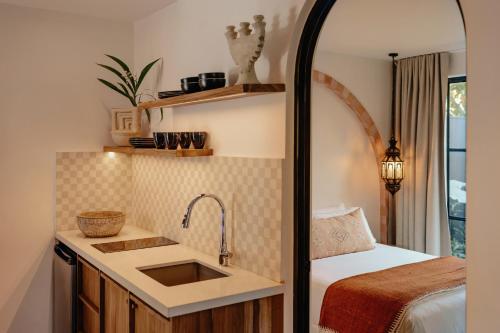 a kitchen with a sink and a bed in a room at Domo Nosara Boutique Hotel in Nosara