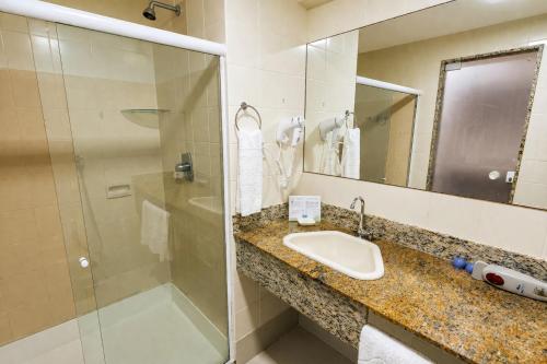 a bathroom with a sink and a shower at Resort Costa Dos Coqueiros in Imbassai