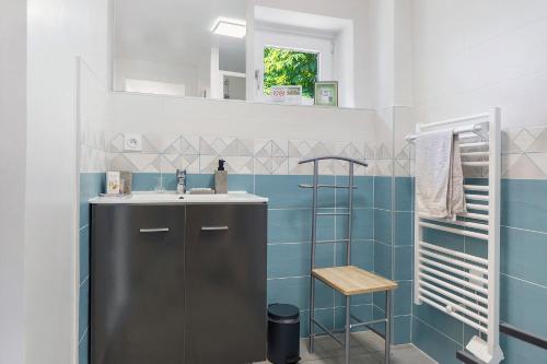 a bathroom with a sink and blue tiles at Le Duzon avec Piscine in Saint-Sylvestre