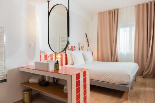a bedroom with a bed with a mirror and a table at Grand Juste in Marseille