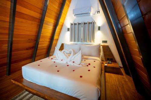 a bed in a room with red flowers on it at Sunset Hill Resort in Kandy