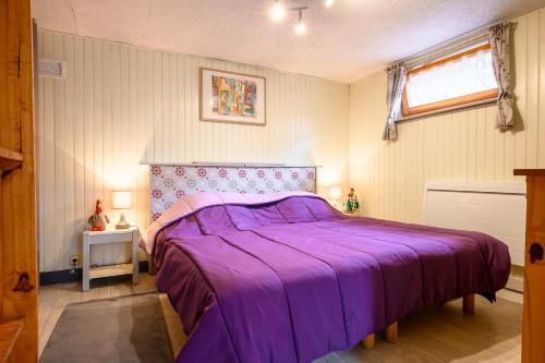 a bedroom with a purple bed and a window at Chambre d'hôte La Châtelaine in Walbach