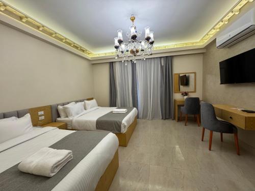 a hotel room with two beds and a chandelier at Dyafa Pyramids Hotel in Cairo