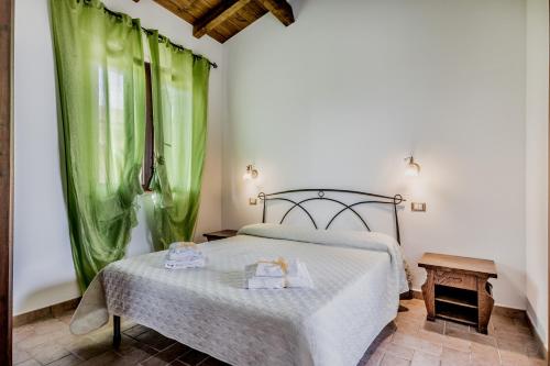 a bedroom with a bed with green curtains at Le Terre Di BAC in Borgo Montenero
