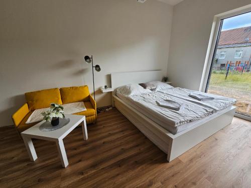 a bedroom with a bed and a couch and a table at Apartmán Meridiem Komárovská in Komárov